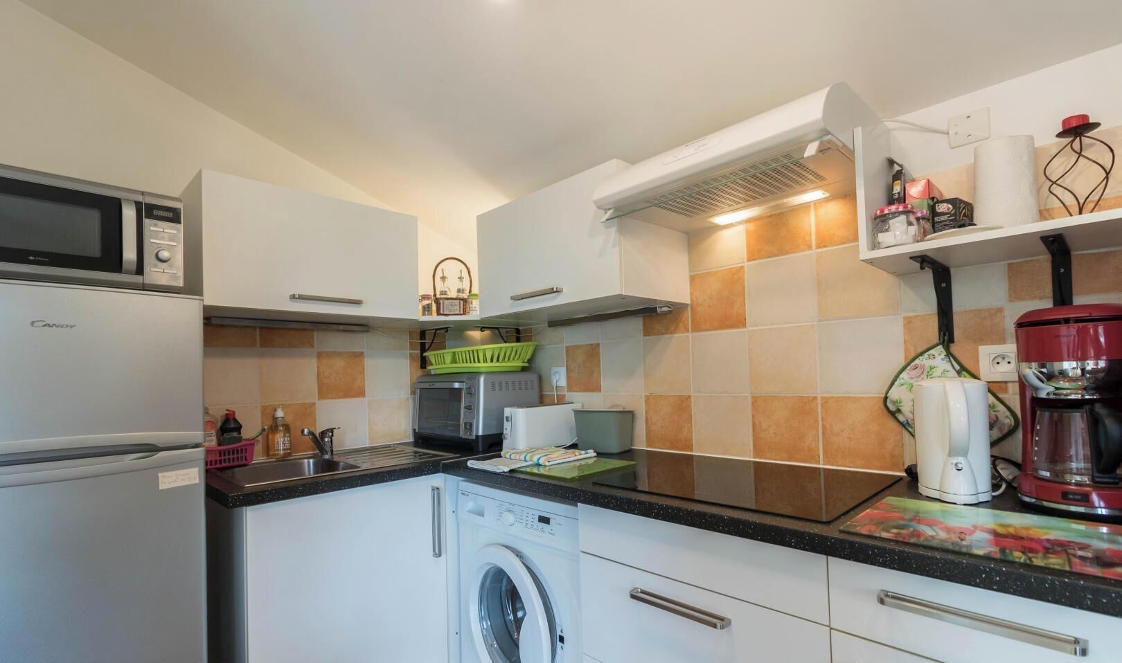 A compact kitchen with a microwave, toaster, and coffee maker.