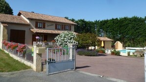 Ein zweistöckiges Gebäude mit einem Ziegeldach, einem verschlossenen Eingang und einem Pool im Hintergrund.