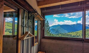 A room with a large window offering a view of a mountainous landscape.