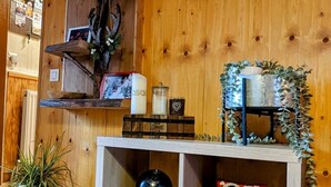 Un intérieur en bois avec des étagères où sont exposés divers objets, notamment une tête de cerf, un globe terrestre et un jouet en peluche représentant une chouette.