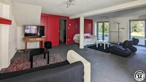 A modern living room with a TV, sofa, and a red accent wall. - Le Cagire - Labarthe-Rivière (Labarthe-Rivière)