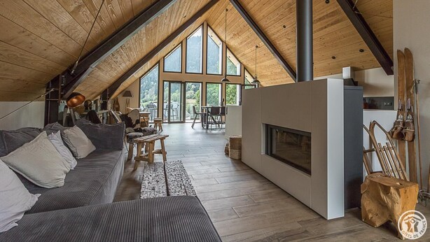 A spacious loft with a high ceiling, large windows, a fireplace, and wooden furniture. - La Grange de Mayrègne - MAYREGNE (MAYREGNE)