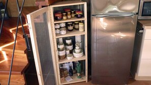 Functional kitchen with cabinet and stainless steel refrigerator.