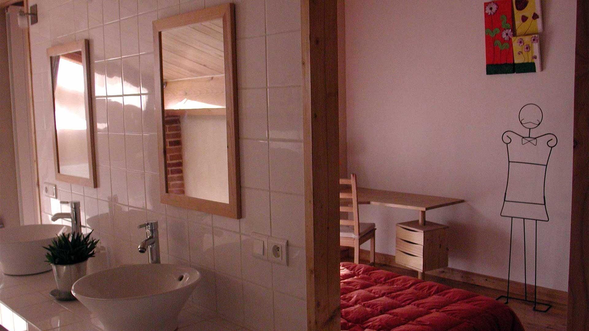 A bathroom with a large mirror, a sink, and a wooden cabinet.