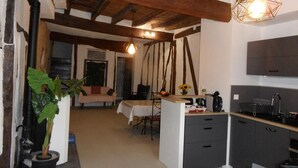 A cozy kitchen with a central island, wooden beams, and a hanging light fixture. - Escapade Lauragaise - Saint-Félix-Lauragais (Saint-Félix-Lauragais)