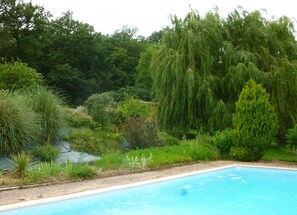 A swimming pool surrounded by lush greenery and trees. - Green Valley - Villaudric (Villaudric)