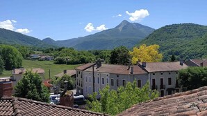 Un pueblo con edificios tradicionales, una montaña destacada al fondo y un cielo despejado.