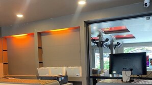 Un área de recepción con un mostrador, computadora y vista al exterior.