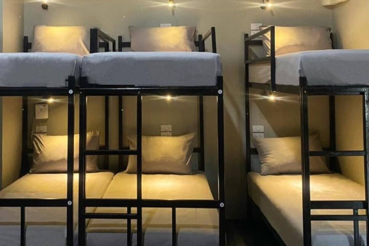 Bunk beds with a simple design, a small table, and a wall-mounted light fixture.