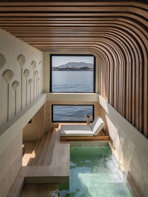 A spa room with a view of a body of water, a bathtub, and a small table with a bowl of fruit. - Soleil Nile Cruise - Mondays from Luxor & Fridays from Aswan (Luxor)