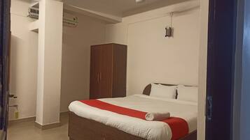 Un dormitorio con cama, armario y equipo de aire acondicionado.