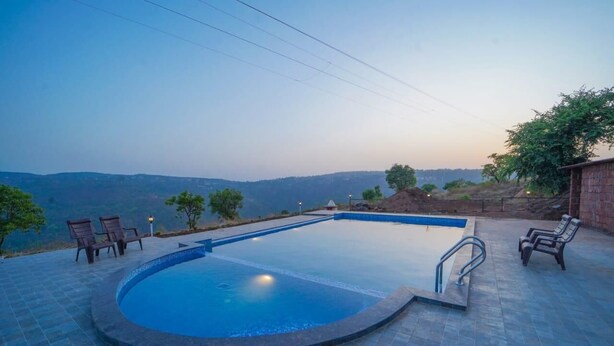 A swimming pool with a view of the hills. - Trattino Resorts (Wai)