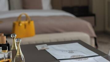 Une chambre d’hôtel bien rangée, avec un lit, une table de chevet sur laquelle sont posés des articles de toilette et un sac à main jaune.