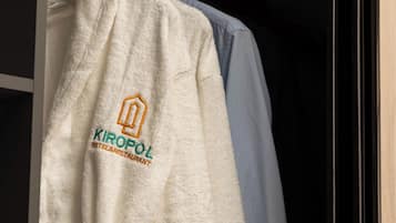 Bata blanca con un logotipo y texto que indica que pertenece al Hotel & Restaurante Kiropol, colgada en un perchero.