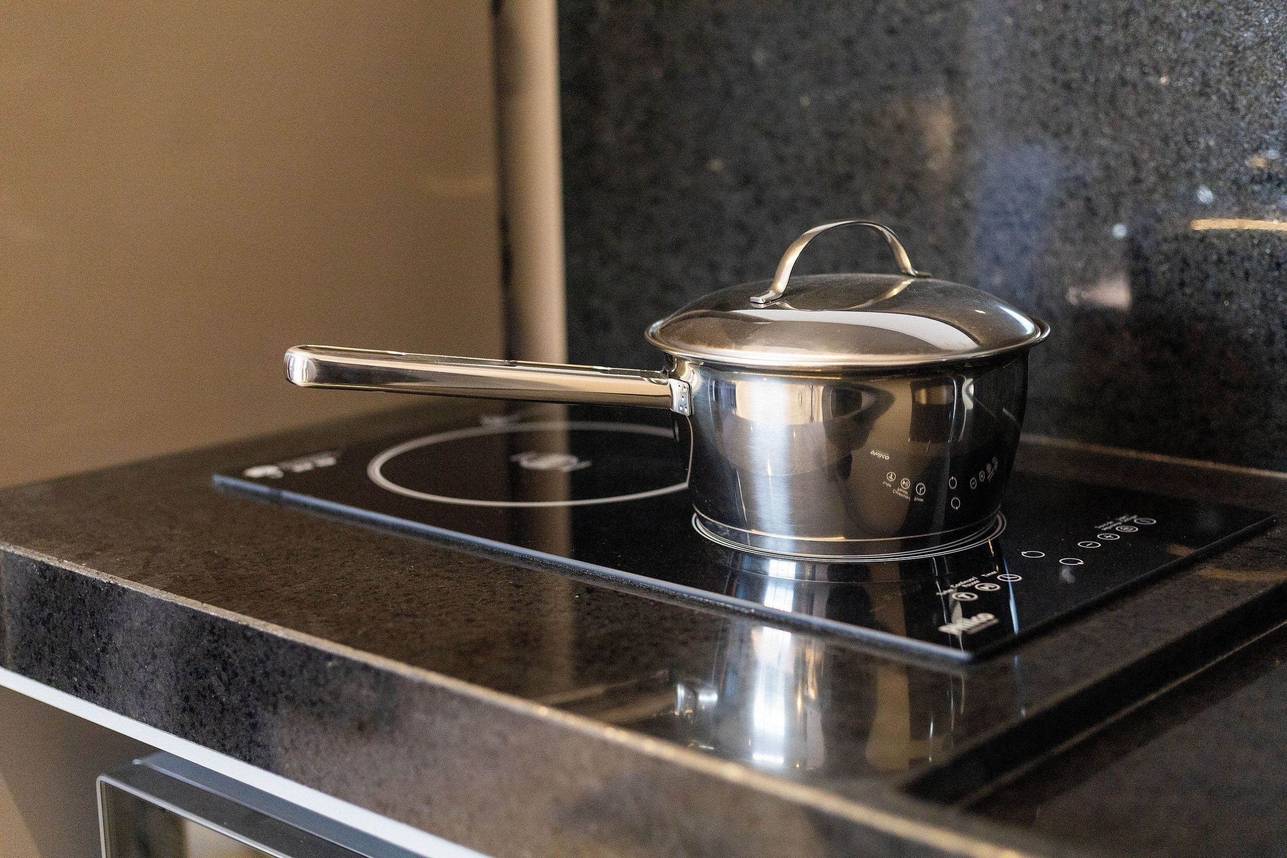 A stainless steel pot on an induction cooktop.