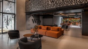 A modern lounge area with a sofa, chairs, and a coffee table. - Way Tambaú - João Pessoa by Carpediem (João Pessoa)