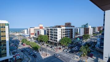 Un paisaje urbano con un edificio moderno que cuenta con una fachada de vidrio extensa y un estacionamiento.