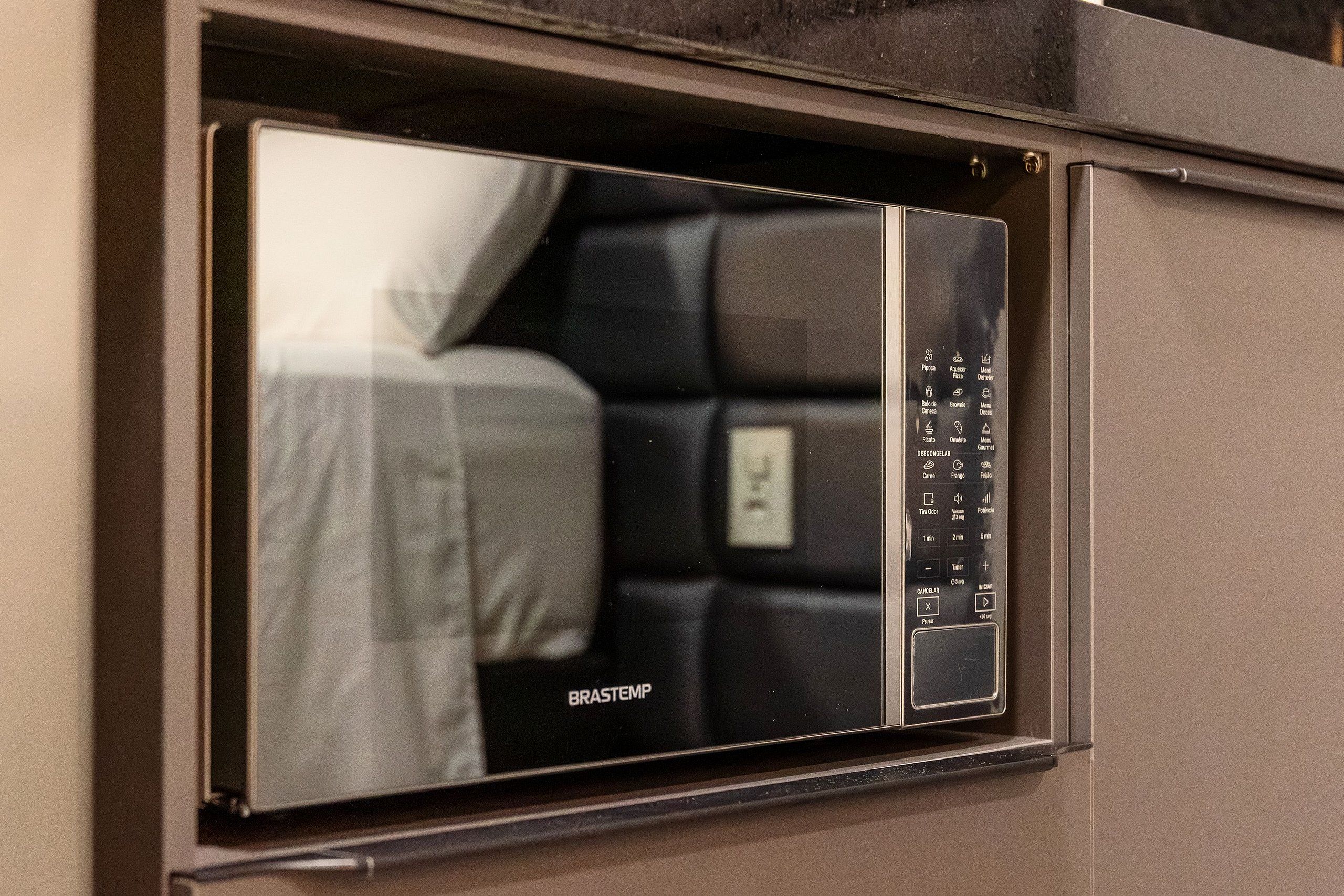 Un four à micro-ondes doté d’un écran numérique et d’un panneau de commande, ce qui indique qu’il fait partie d’un ensemble de cuisine compact.