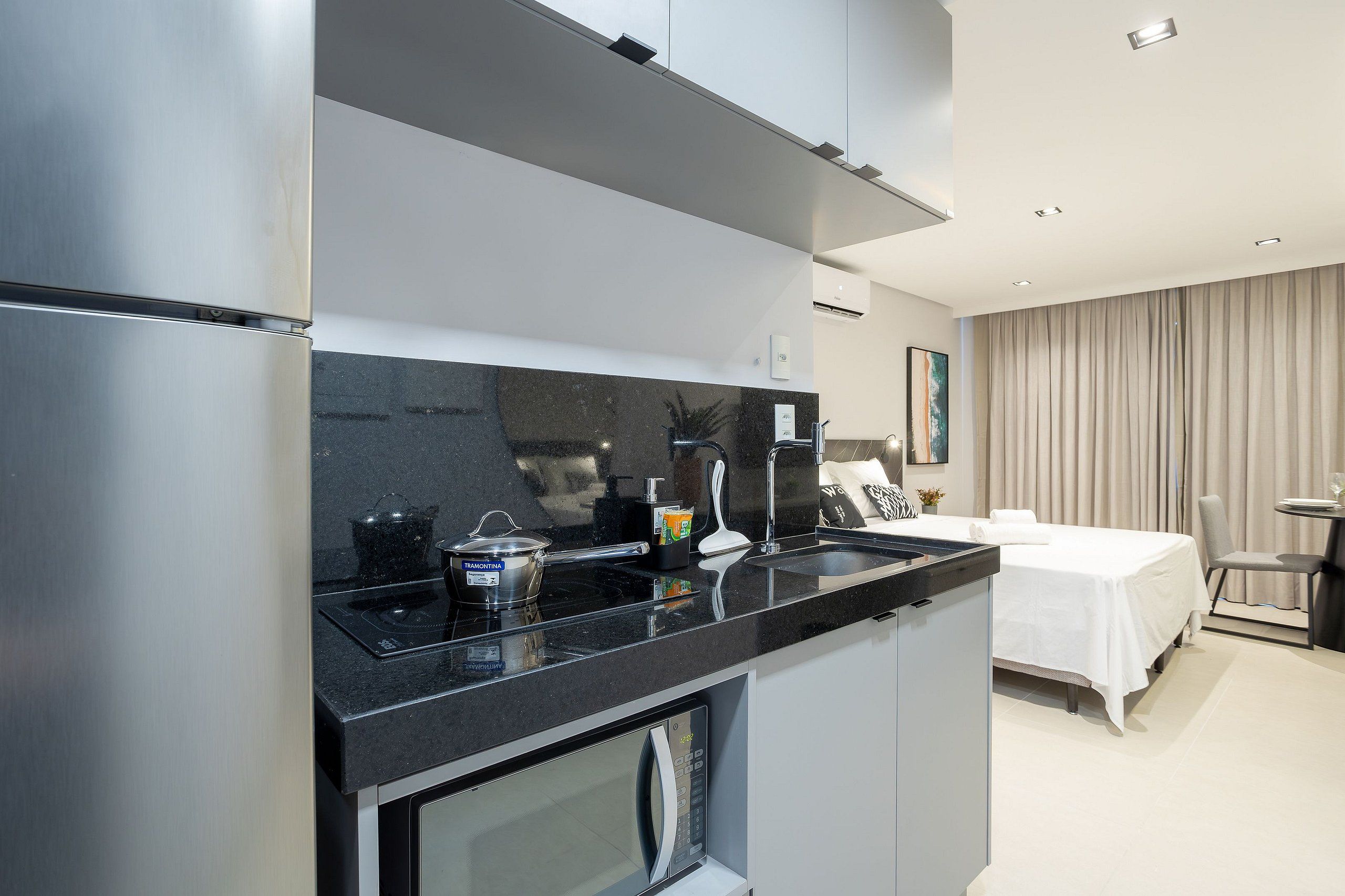 Una cucina moderna con forno a microonde, piano cottura e lavello.