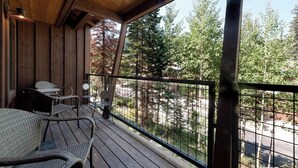 A wooden deck with wicker chairs and a metal table, overlooking a forested area. - Pet Friendly Black Bear Townhome across from Purg - Views - Free Shuttle (Durango)