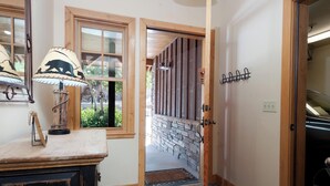A hallway with a stone wall, wooden door, and a lamp on a wooden surface. - Pet Friendly Black Bear Townhome across from Purg - Views - Free Shuttle (Durango)