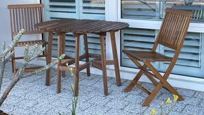 A wooden table and two chairs outside a window with blinds. - A cosy private room in Eglinton. (Eglinton)