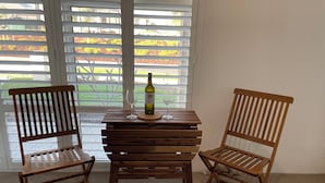 Two wooden chairs and a small table with a wine bottle and glass. - A cosy private room in Eglinton. (Eglinton)