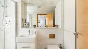 A bathroom with a marble sink, a mirror, and a shower. - 4 Guests - 2 Bedrooms - Quick Links Central London (London)