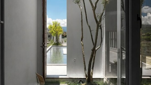 A room with a sliding glass door leading to a pool, a small tree, and a chair. - Water House (Yilan)