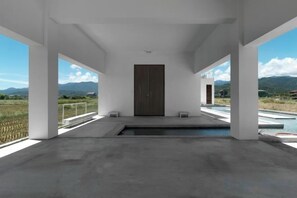 Un interior moderno con un ventanal grande, una puerta y una zona de piscina.