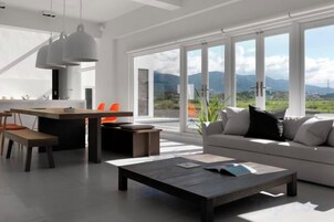 Una sala de estar moderna con sofá, mesa de centro y comedor.