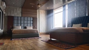 Un dormitorio moderno con una cama grande, otra más pequeña y un área de descanso.