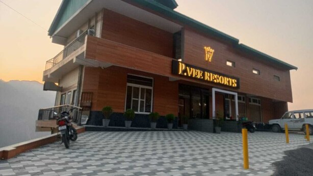 Un edificio de dos pisos con un letrero que dice "P.V. VEE RESORTS".