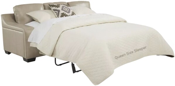 A bed with a beige headboard and a quilted cover labeled "Queen Size Sleeper".