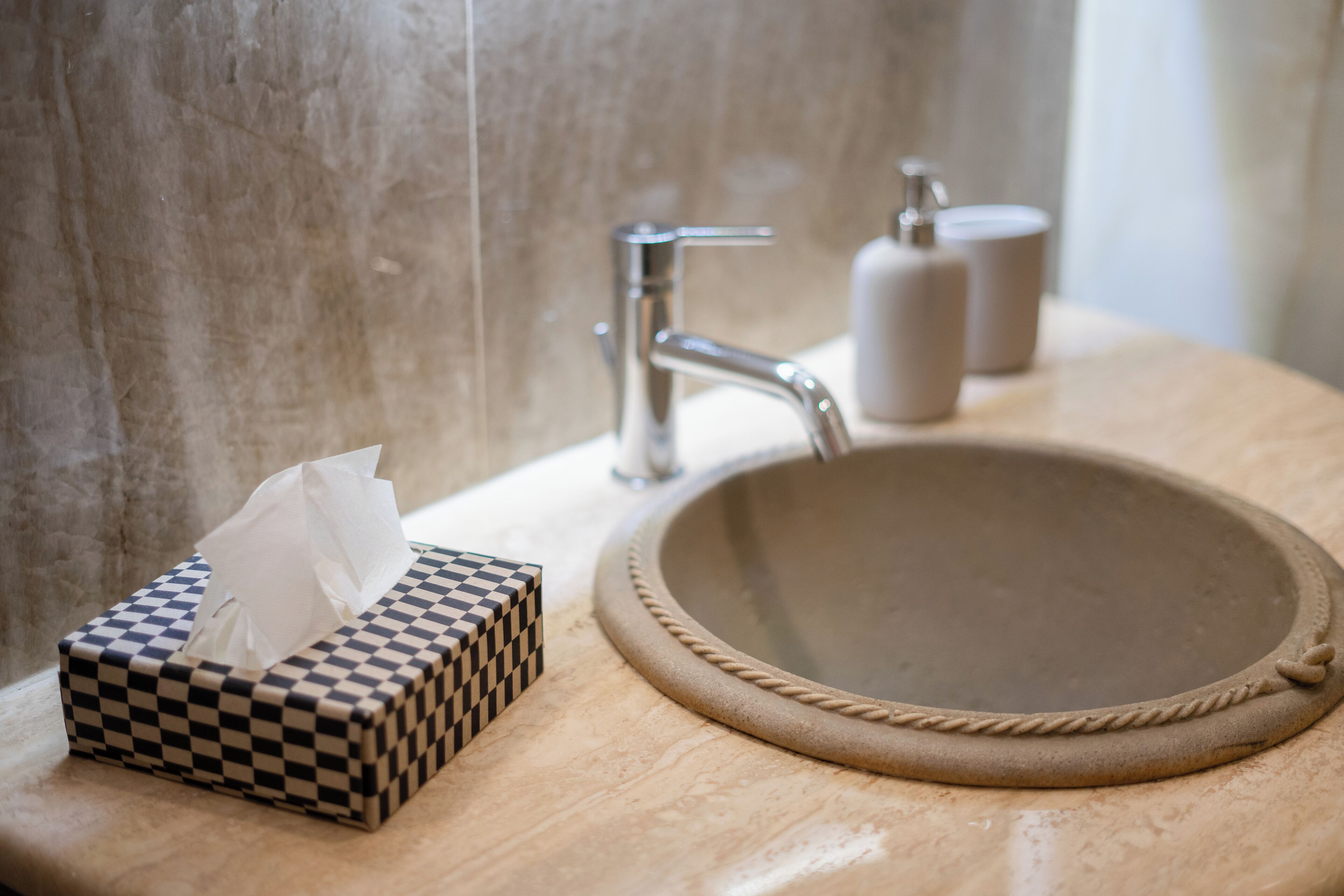 Ein Waschtisch mit einer karierten Papiersammlung und einem Becken mit Seilbindung.