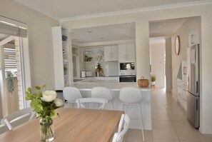 Enjoy meals in the well-lit kitchen with a central island, sink, and stainless steel refrigerator.