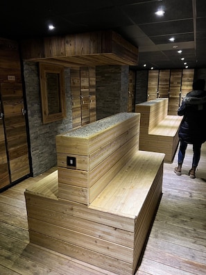 Una sala de sauna con bancos de madera y paredes de piedra.