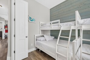 Your coastal getaway awaits in this charming twin over full size bunk room on the third floor with shiplap walls painted in soothing aqua tones and crisp white bedding ready for restful sleep. - Luxury Waterfront Townhome | Pool, Boat Slip & Sunset Views (Corpus Christi)