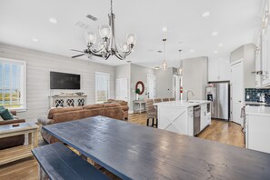 A modern kitchen with white cabinets and a stainless steel refrigerator. - Luxury Waterfront Townhome | Pool, Boat Slip & Sunset Views (Corpus Christi)