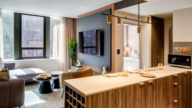 A modern kitchen with a built-in microwave, a wooden island, and a large window.