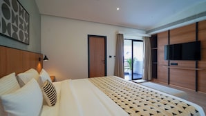 A modern hotel room with a large bed, a flat-screen TV, a balcony with curtains, and a wooden panel wall. - Olive Hotel Benz Circle, Vijayawada by Embassy Group (Vijayawada)