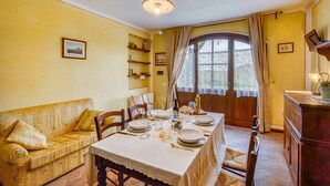 Un comedor con una mesa dispuesta para cuatro personas, un sofá y un aparador de madera.