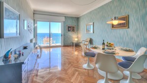 A modern dining area with a view of the sea, a wooden floor, and contemporary furniture. - Sofy Apartment - Sea View (Sanremo)