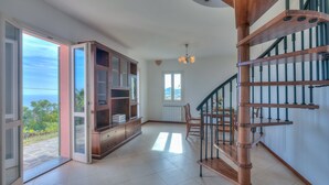 A spacious room with a wooden staircase, a large open cabinet, and a view through an open door. - Palms Villa - Sea View (Sanremo)