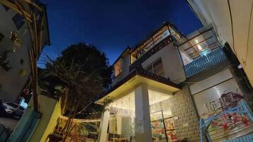 A two-story building with a balcony and a covered outdoor area.