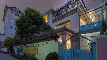 A residential building with traditional architecture, a balcony, and a starry night sky.
