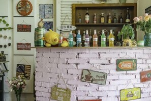 A bar area with a white brick wall, shelves with bottles, and various signs. - Jianying (Lijiang)