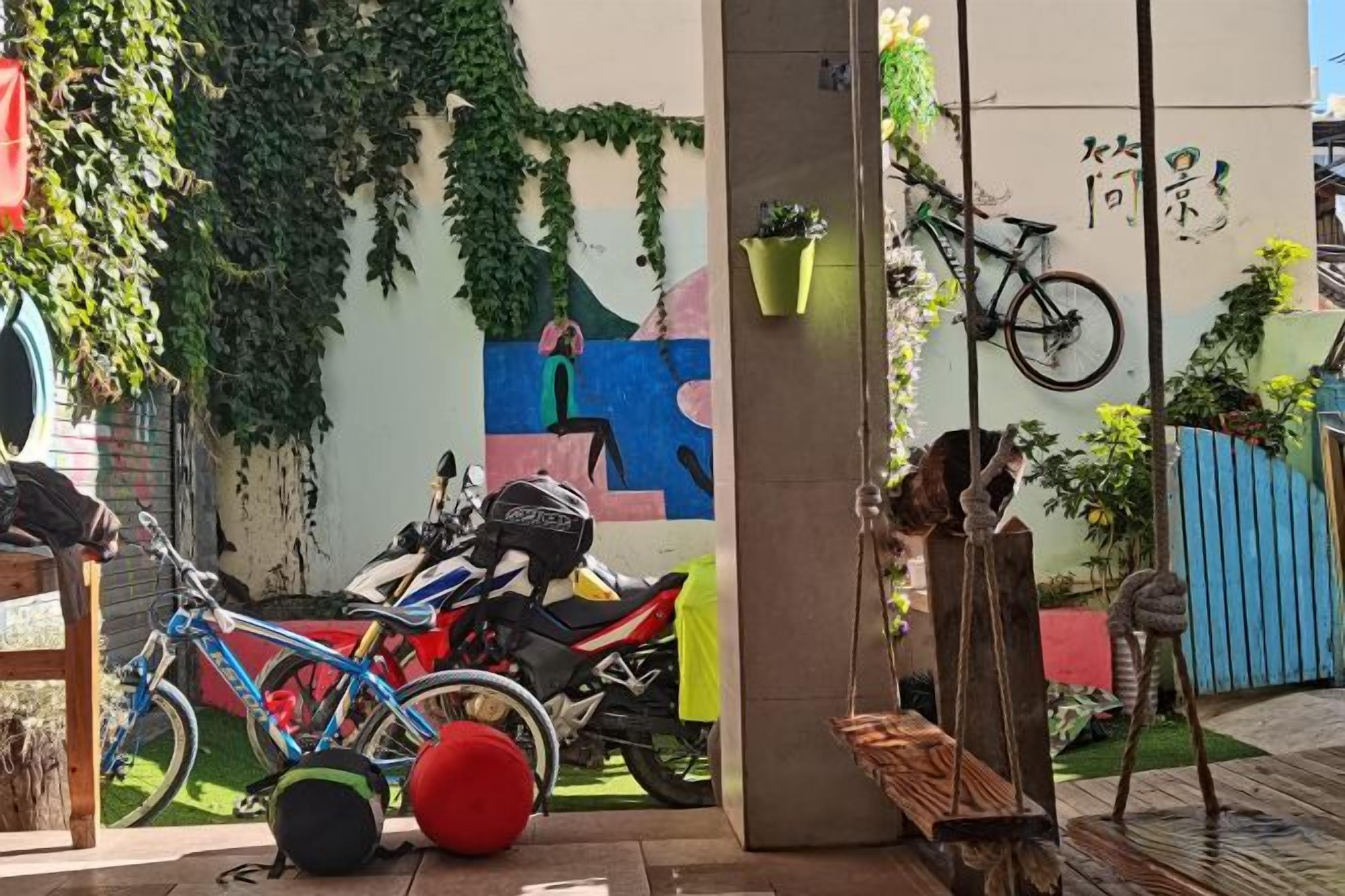 A courtyard with a bicycle, a motorcycle, and a bench.