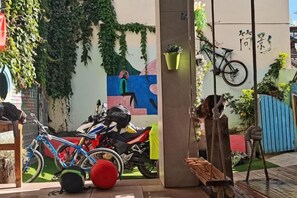A courtyard with a bicycle, a motorcycle, and a bench. - Jianying (Lijiang)
