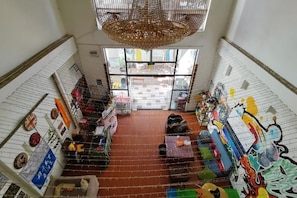 A hotel lobby with a high ceiling, a chandelier, a red carpet, and a view through the glass door. - Jianying (Lijiang)